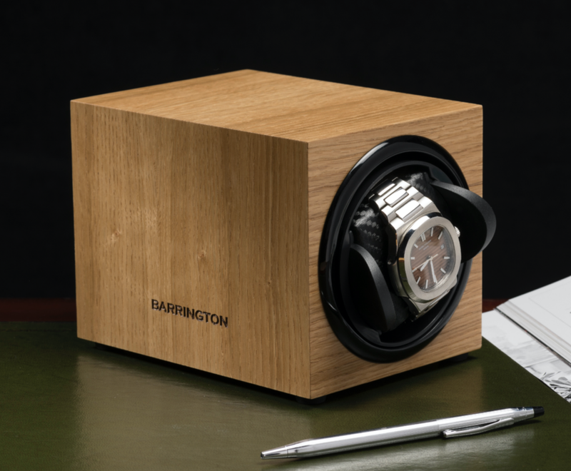 Wood watch winder and pen on desk