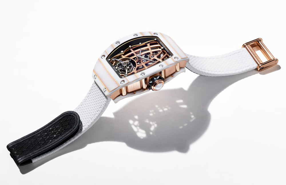 Luxury watch with white strap and rose gold case on a white background